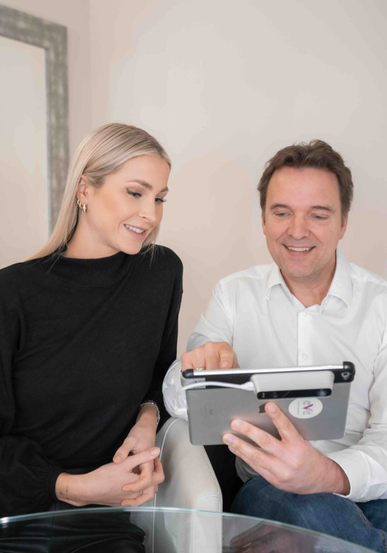 Dr. Christian Döbler mit einer Patientin in Düsseldorf am Ipad und zeigt ihr was
