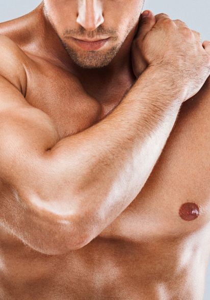Mann zeigt muskolöse Brust nach Gynäkomastie-OP